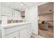 Bright bathroom features a white vanity, tile backsplash, and a view into an adjacent room at 7815 Conifer Rd, Denver, CO 80221