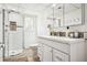 This bathroom features updated lighting, a curved shower stall, and sleek white vanity at 7815 Conifer Rd, Denver, CO 80221