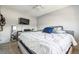 A bright bedroom with neutral decor, featuring a cozy bed and a wall-mounted television at 7815 Conifer Rd, Denver, CO 80221