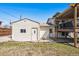 The detached garage has two white doors and is located next to the back of the house with an elevated deck at 7815 Conifer Rd, Denver, CO 80221