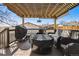 Inviting outdoor patio featuring wicker furniture, a grill, and a covered seating area at 7815 Conifer Rd, Denver, CO 80221