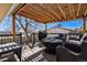 Inviting outdoor patio featuring wicker furniture, a grill, and a covered seating area at 7815 Conifer Rd, Denver, CO 80221