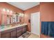 Bathroom with double sink vanity, cabinets, and dual mirrors at 437 Buckskin Rd, Berthoud, CO 80513