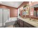 Bathroom with double sink vanity, shower over tub, and tiled walls at 437 Buckskin Rd, Berthoud, CO 80513
