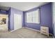 Bedroom with a large window, neutral carpet, closet, and purple walls at 437 Buckskin Rd, Berthoud, CO 80513