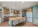 Bright kitchen with a kitchen island with bar seating, stainless steel appliances, and wooden cabinetry at 437 Buckskin Rd, Berthoud, CO 80513