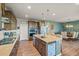 Bright kitchen with a kitchen island, stainless steel appliances, and hardwood floors next to the dining room at 437 Buckskin Rd, Berthoud, CO 80513