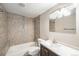 Nicely tiled bathroom with granite countertop sink, bath, and modern light fixture at 6147 Dunraven, Golden, CO 80403