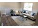 Bright living room with wood floors, a large window, and modern furniture at 6147 Dunraven, Golden, CO 80403