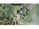 A bird's-eye view displays a vast property surrounded by trees, including its unique triangular driveway at 3842 Estates Cir, Larkspur, CO 80118