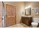 Rustic bathroom featuring wood cabinets, granite countertop and wood door at 3842 Estates Cir, Larkspur, CO 80118
