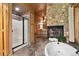 Elegant bathroom with a walk-in shower, soaking tub, and stone accent wall, offering a spa-like retreat at 3842 Estates Cir, Larkspur, CO 80118