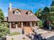 Charming home with stone accents, wood porch, and manicured landscaping at 3842 Estates Cir, Larkspur, CO 80118