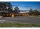 Single story home featuring a long driveway and three car garage at dusk at 3842 Estates Cir, Larkspur, CO 80118