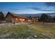 Home featuring a covered porch, stone columns, and expansive lawn at 3842 Estates Cir, Larkspur, CO 80118