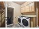 Convenient laundry room with modern washer and dryer, storage cabinets, and a granite countertop at 3842 Estates Cir, Larkspur, CO 80118