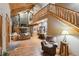 Open living space with stone accent wall, wooden beams, and staircase, creating a rustic yet modern ambiance at 3842 Estates Cir, Larkspur, CO 80118