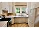 Bright kitchen featuring white cabinets, stainless steel sink, and natural light from large windows at 723 Steele St, Denver, CO 80206