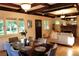 Sun-filled living room with hardwood floors, large windows, coffered ceiling, and open dining area, exudes warmth at 723 Steele St, Denver, CO 80206