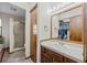 Bright bathroom features a wooden vanity, white countertop, oval sink, and a closet for ample storage at 44011 Morning Star Ct, Elizabeth, CO 80107