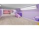 Bright bonus room with pink and purple color scheme, carpeting, built-in shelving, and creative decor at 44011 Morning Star Ct, Elizabeth, CO 80107