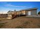 Exterior view of the home featuring a deck, patio and stairs leading to the fenced in yard at 44011 Morning Star Ct, Elizabeth, CO 80107