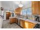 Bright kitchen with stainless appliances, double basin sink, wooden cabinetry, and outdoor views at 44011 Morning Star Ct, Elizabeth, CO 80107