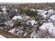Aerial view of snow-covered townhomes surrounded by trees and with ample parking on a cloudy day at 4009 Wonderland Hill Ave, Boulder, CO 80304