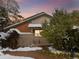 Charming home exterior in winter features a brick facade and snow covered landscaping at dusk at 4009 Wonderland Hill Ave, Boulder, CO 80304