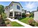 Beautiful backyard has a covered deck, green lawn, flower garden, and walkway, surrounded by mature trees at 474 S Vine St, Denver, CO 80209