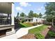 Well-maintained backyard has a covered deck, green lawn, flower garden, and walkway at 474 S Vine St, Denver, CO 80209