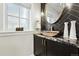Chic powder room with black herringbone tile, stone sink, and a gold faucet at 474 S Vine St, Denver, CO 80209