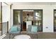 View from the covered deck to the open floor plan in kitchen, with chairs for lounging at 474 S Vine St, Denver, CO 80209