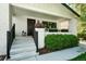 Inviting front porch with white brick columns, black railings, a dark wood door, and decorative potted plants at 474 S Vine St, Denver, CO 80209