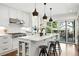 Bright kitchen with stainless steel appliances, white cabinets, a large island, and hardwood floors at 474 S Vine St, Denver, CO 80209