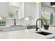 Close-up shot of bright kitchen island with a sink, modern faucet, and an open view of the backyard at 474 S Vine St, Denver, CO 80209