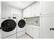 Functional laundry room with washer, dryer, utility sink, and ample storage at 474 S Vine St, Denver, CO 80209