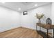 Bright basement featuring wood-look floors, white walls, and a stylish console table at 9565 W Lake Pl, Littleton, CO 80123
