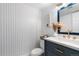 This powder room boasts striking wallpaper, a modern sink, and chic decor, creating a stylish and inviting space at 9565 W Lake Pl, Littleton, CO 80123