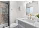 This bathroom offers a glass-enclosed shower, complemented by marble tiling and brass fixtures at 9565 W Lake Pl, Littleton, CO 80123