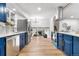 Modern kitchen featuring blue cabinetry, stainless steel appliances, and a view to the living area at 9565 W Lake Pl, Littleton, CO 80123