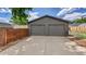 A detached two-car garage with gray doors, exterior lights, and a concrete driveway at 2990 S Sherman St, Englewood, CO 80113