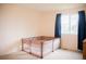 Bright bedroom with a large window and a playpen in the center at 7961 Jared Way, Littleton, CO 80125