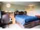 Comfortable bedroom featuring a large bed with storage and adjacent workspace and shelving at 7961 Jared Way, Littleton, CO 80125