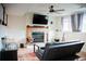 Cozy living room with a stone fireplace, ceiling fan, and comfortable seating at 7961 Jared Way, Littleton, CO 80125