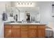 Bathroom features a dual sink vanity with tiled floors and a large mirror at 4950 Mt Cameron Dr, Brighton, CO 80601
