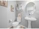 Cozy powder room with pedestal sink, wood-look flooring, and charming decor at 4950 Mt Cameron Dr, Brighton, CO 80601