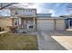 Charming two-story home features a three-car garage, inviting porch, and stone pillar accents at 4950 Mt Cameron Dr, Brighton, CO 80601