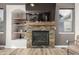 Living room featuring a stone fireplace with wooden mantle, built-in shelving, and modern decor at 4950 Mt Cameron Dr, Brighton, CO 80601