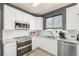 Kitchen featuring white subway tile backsplash, stainless steel appliances, and white cabinetry at 4950 Mt Cameron Dr, Brighton, CO 80601